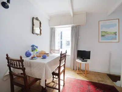 a dining room with a table and chairs and a television at Kernyck in Port Isaac