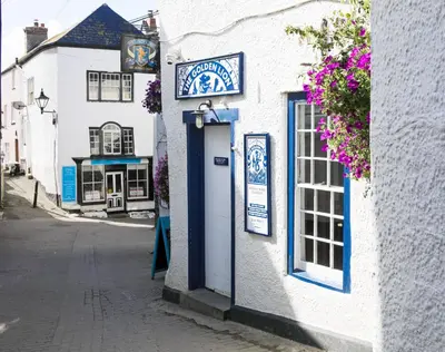 a white building with a sign on it on a street at Kernyck in Port Isaac