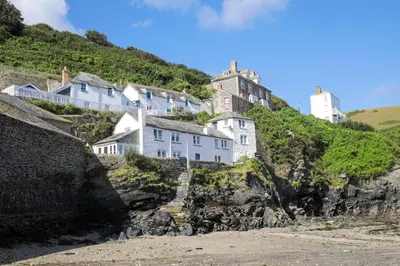 a group of houses on a cliff next to the beach at Kernyck in Port Isaac