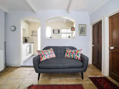 a living room with a couch and a kitchen at Kernyck in Port Isaac
