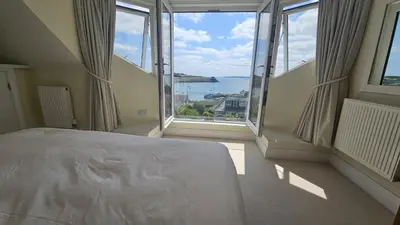 a bedroom with a bed with a view of the ocean at Highlands in Saint Mawes