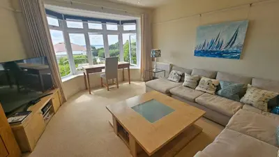 a living room with a couch and a table at Highlands in Saint Mawes