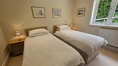 two twin beds in a bedroom with a window at Highlands in Saint Mawes