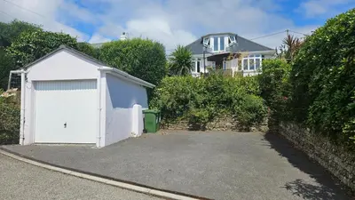 a white garage in front of a house at Highlands in Saint Mawes
