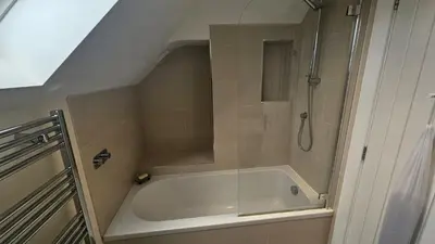 a bathroom with a shower and a white tub at Highlands in Saint Mawes