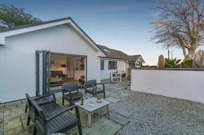 a patio with chairs and a table in front of a house at 3 Bed in Carbis Bay oc-p33004 in Carbis Bay