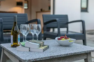 a table with a bottle of wine and a bowl of fruit at 3 Bed in Carbis Bay oc-p33004 in Carbis Bay