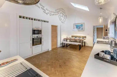 a kitchen with white walls and a dining room with a table at 3 Bed in Carbis Bay oc-p33004 in Carbis Bay
