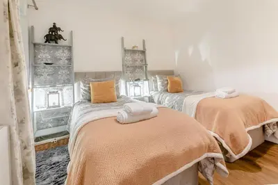 a bedroom with two beds with orange sheets at 3 Bed in Carbis Bay oc-p33004 in Carbis Bay