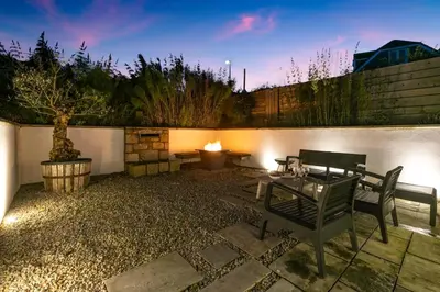a patio with a table and benches and a wall at 3 Bed in Carbis Bay oc-p33004 in Carbis Bay