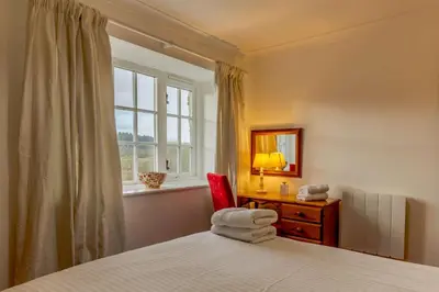 a bedroom with a bed and a desk and a window at 1 Bed in Two Waters Foot oc-a27332 in Warleggan