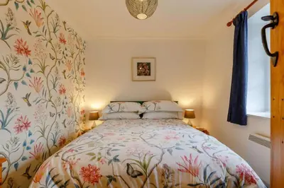 a bedroom with a bed with a floral wallpaper at 1 Bed in Two Waters Foot oc-n27333 in Warleggan