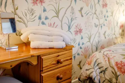 a pile of towels on a dresser in a bedroom at 1 Bed in Two Waters Foot oc-n27333 in Warleggan