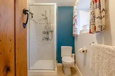 a bathroom with a toilet and a shower with a glass shower door at 1 Bed in Two Waters Foot oc-n27333 in Warleggan