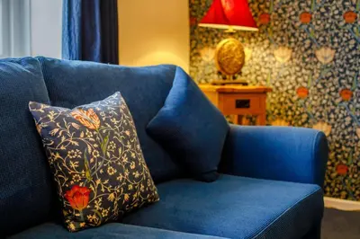 a blue couch with a pillow on it with a lamp at 2 Bed in Two Waters Foot oc-s27334 in Warleggan