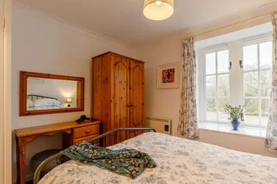 a bedroom with a bed and a mirror and a window at 2 Bed in Two Waters Foot oc-s27334 in Warleggan