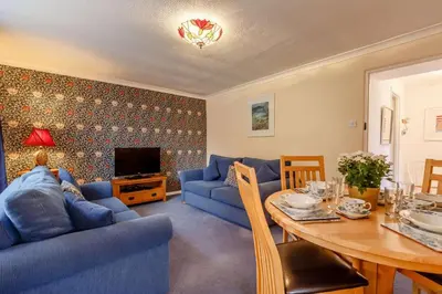a living room with a blue couch and a table at 2 Bed in Two Waters Foot oc-s27334 in Warleggan