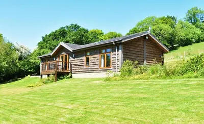 a small wooden house on a hill with a yard at 3 Bed in Two Waters Foot oc-m27335 in Cardinham