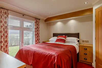 a bedroom with a bed with a red blanket and a window at 3 Bed in Two Waters Foot oc-m27335 in Cardinham