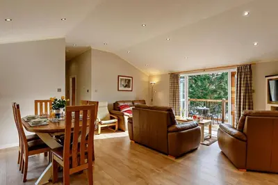 a living room with a table and a dining room at 3 Bed in Two Waters Foot oc-m27335 in Cardinham