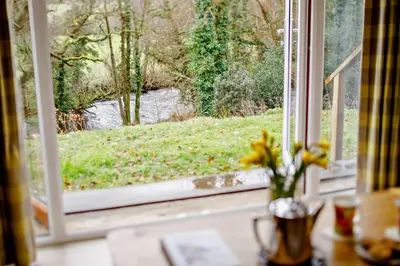 a window with a view of a field and a river at 3 Bed in Two Waters Foot oc-r27336 in Cardinham