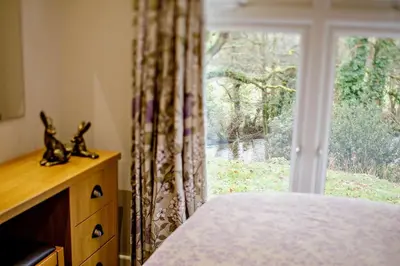 a bedroom with a window with a view of a yard at 3 Bed in Two Waters Foot oc-r27336 in Cardinham