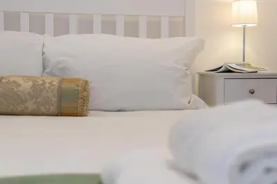 a bed with white sheets and a pillow and a lamp at 3 Bed in Fowey oc-g33050 in Fowey