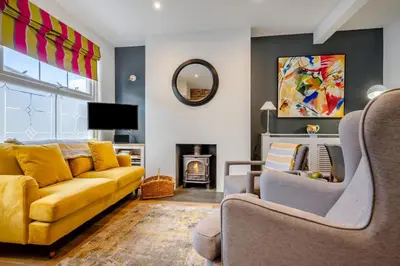 a living room with a yellow couch and a fireplace at 3 Bed in Fowey oc-g33050 in Fowey