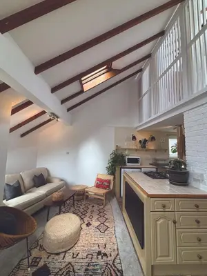 a living room with a couch and a kitchen at Central loft apartment sea views in Falmouth