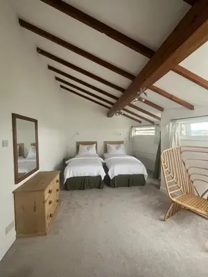 a bedroom with two beds and a mirror at Central loft apartment sea views in Falmouth