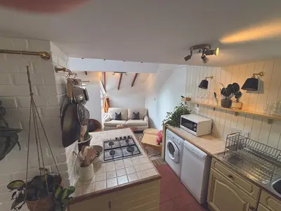 a kitchen with a stove top oven next to a couch at Central loft apartment sea views in Falmouth