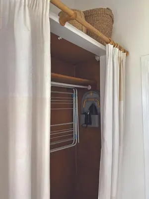 a closet with a curtain and a towel rack and a window at Central loft apartment sea views in Falmouth
