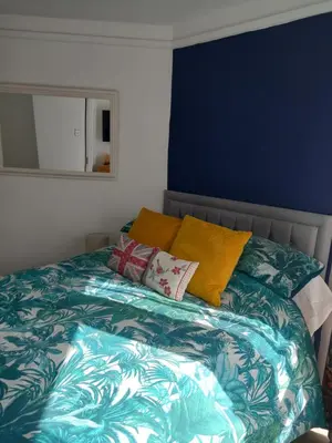 a bedroom with a bed with a blue wall at Garden room in St Ives