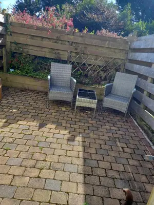 two chairs on a patio next to a fence at Garden room in St Ives