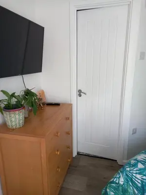 a bedroom with a dresser with a tv on top of it at Garden room in St Ives