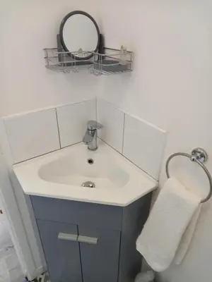 a bathroom with a sink and a mirror on the wall at Garden room in St Ives