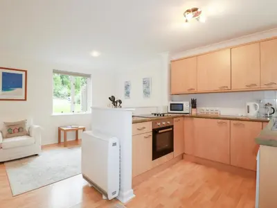 a kitchen with wooden cabinets and a white refrigerator at Acorns in Falmouth