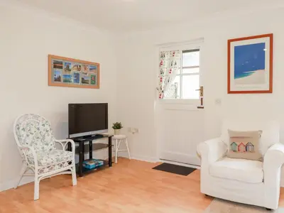 a living room with a chair and a television at Acorns in Falmouth