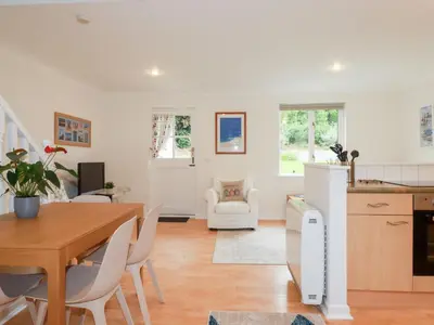 a kitchen and living room with a table and chairs at Acorns in Falmouth