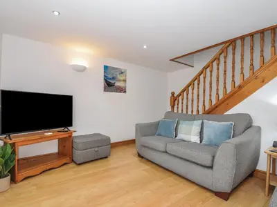 a living room with a couch and a flat screen tv at Norvys in Tintagel