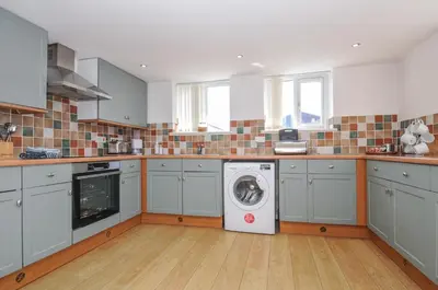 a kitchen with a washing machine in the middle at Norvys in Tintagel