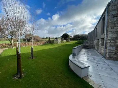 a building with a green lawn next to a building at Parc an Praze - Cornwall Retreat by the Sea in Perranuthnoe