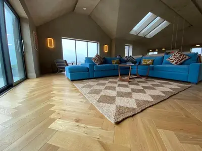 a living room with a blue couch and a rug at Parc an Praze - Cornwall Retreat by the Sea in Perranuthnoe