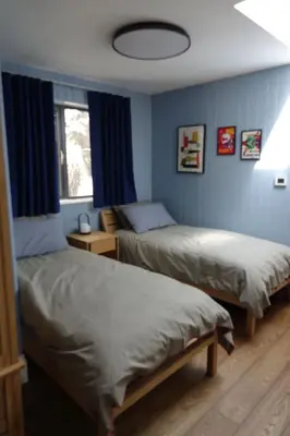 two beds in a bedroom with blue walls at Chymaen - Magnificent Cornish coastal home in Marazion