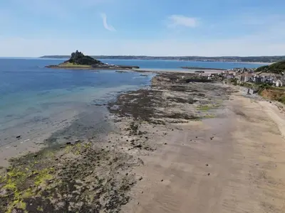 an aerial view of a sandy beach and the ocean at Chymaen - Magnificent Cornish coastal home in Marazion