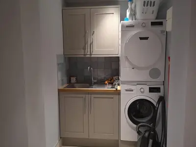 a kitchen with a washing machine and a washer at Chymaen - Magnificent Cornish coastal home in Marazion