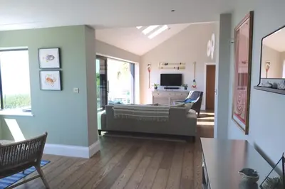 a living room with a couch and a television at Chymaen - Magnificent Cornish coastal home in Marazion