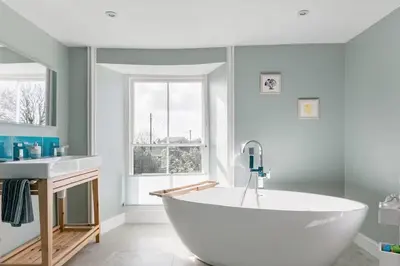a bathroom with a large white tub and a sink at Grade II Listed 17th-Century Rectory in Cornwall in Perranuthnoe