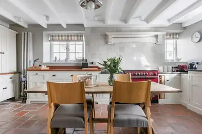a kitchen with a wooden table and chairs at Grade II Listed 17th-Century Rectory in Cornwall in Perranuthnoe
