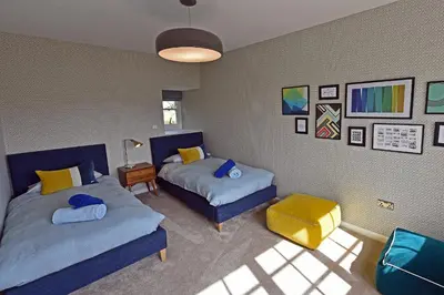 a bedroom with two beds and a table and a lamp at Grade II Listed 17th-Century Rectory in Cornwall in Perranuthnoe